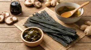 Foglie di alga kombu essiccata con ciotole di brodo e kombu reidratato su un tavolo di legno