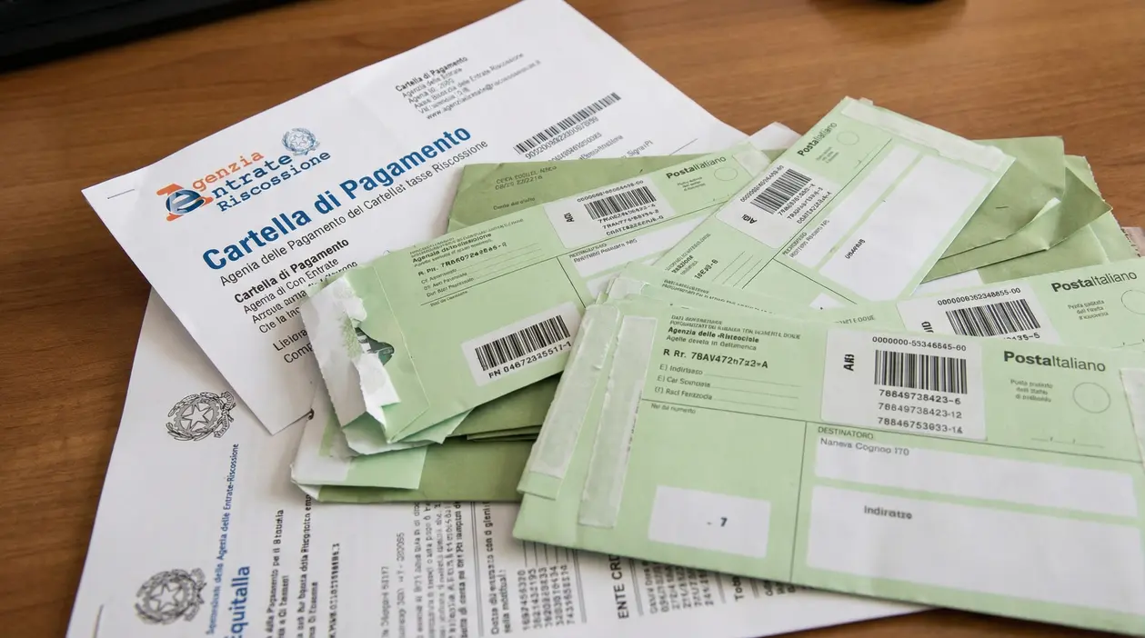 Cartella di pagamento e buste di notifica su un tavolo, legate a cartelle esattoriali e riscossione