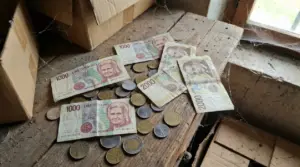 Vecchie banconote e monete in lire italiane appoggiate su un tavolo impolverato in soffitta
