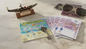 Gratta e vinci Turista per Sempre con banconote da 50 euro, chiave, passaporti e occhiali su un tavolo