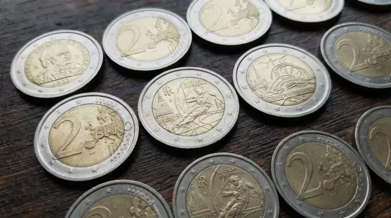 Monete da due euro con diverse incisioni commemorative su una superficie in legno