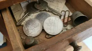 Monete italiane rare in un vecchio cassetto con chiavi, ditale e graffette