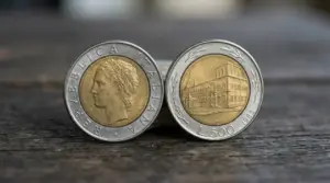Due monete da 500 lire bimetalliche del 1982, con profilo femminile e veduta di un edificio, su piano in legno